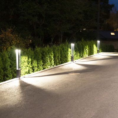 funk_pillars_illuminating_your_yard_ledstorefi_1 - LedStore Yöaikaan kaareutuvaa polkua valaisee LedStore.fi:n modernit, korkeat LED-valaisimet. Nämä valot luovat lämpimän hehkun polun pinnalle, samalla kun siististi leikattu pensasaita reunustaa polkua ja tuo vehreyttä näkymään.