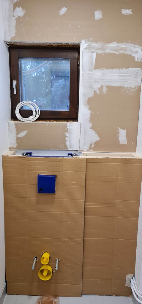 20210125_143040 - LedStore Partially covered bathroom wall with a cardboard, a blue square, and yellow fittings; twisted white cables for on the window ledge.