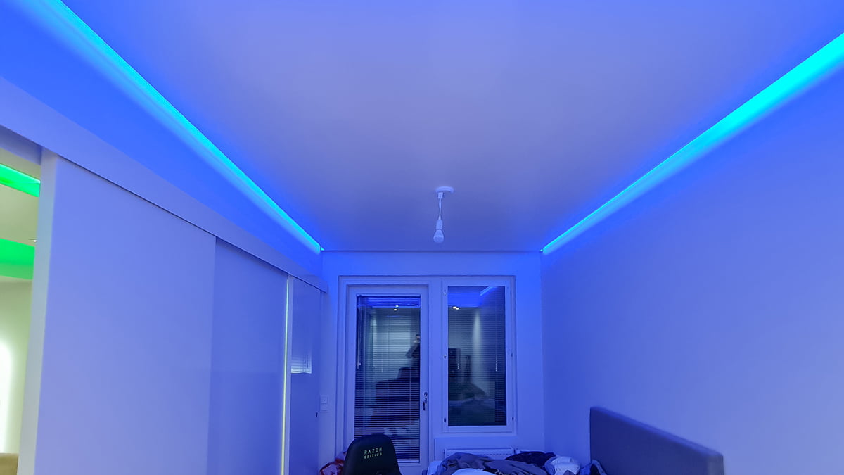 Indirekt ljus i taket. ett blått ögonblick i det låga taket i ett sovrum