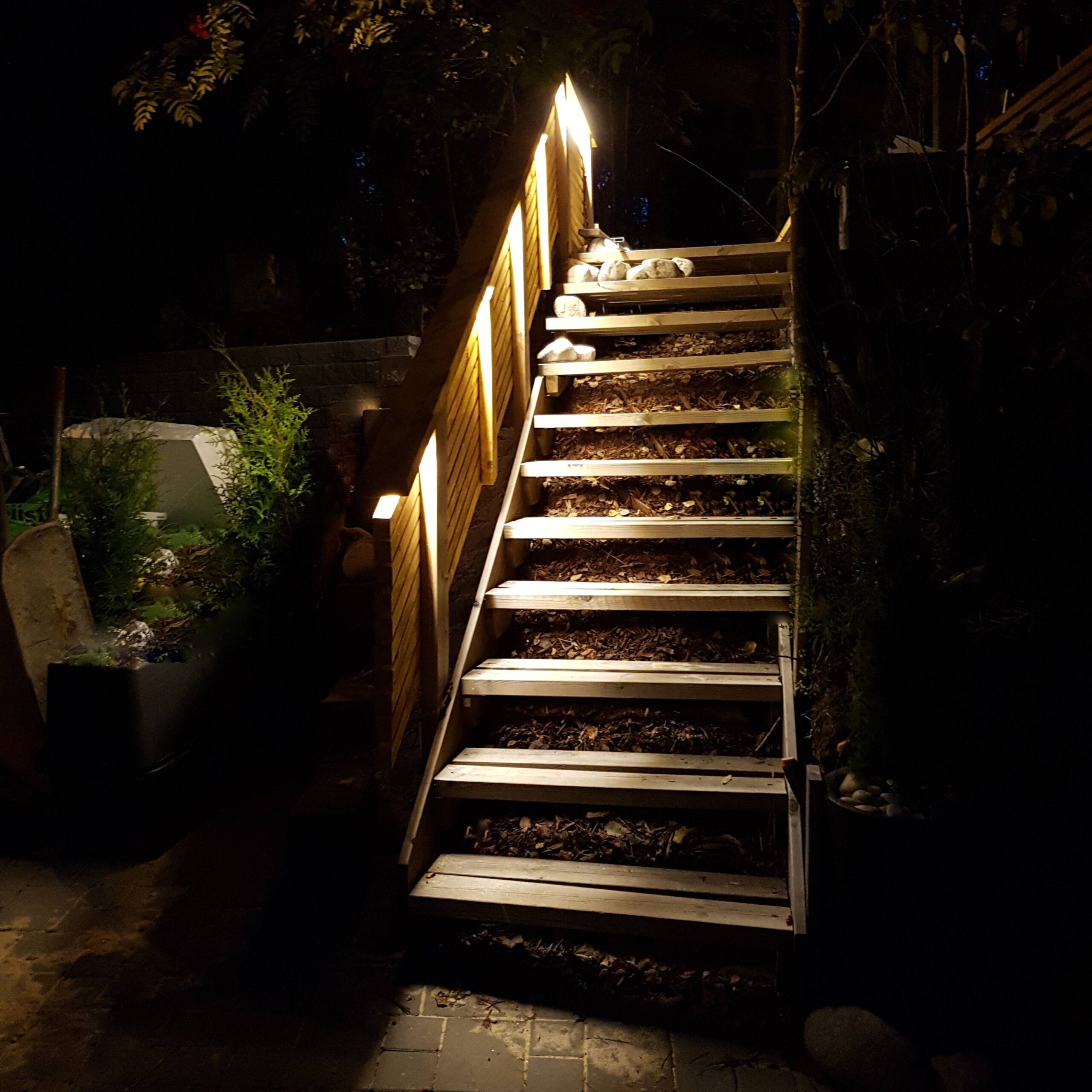 Outdoor wooden stairs illuminated with warm LED outdoor lighting and LED strip lights. - LedStore Led-nauhavalaistus puuportaiden kaiteessa