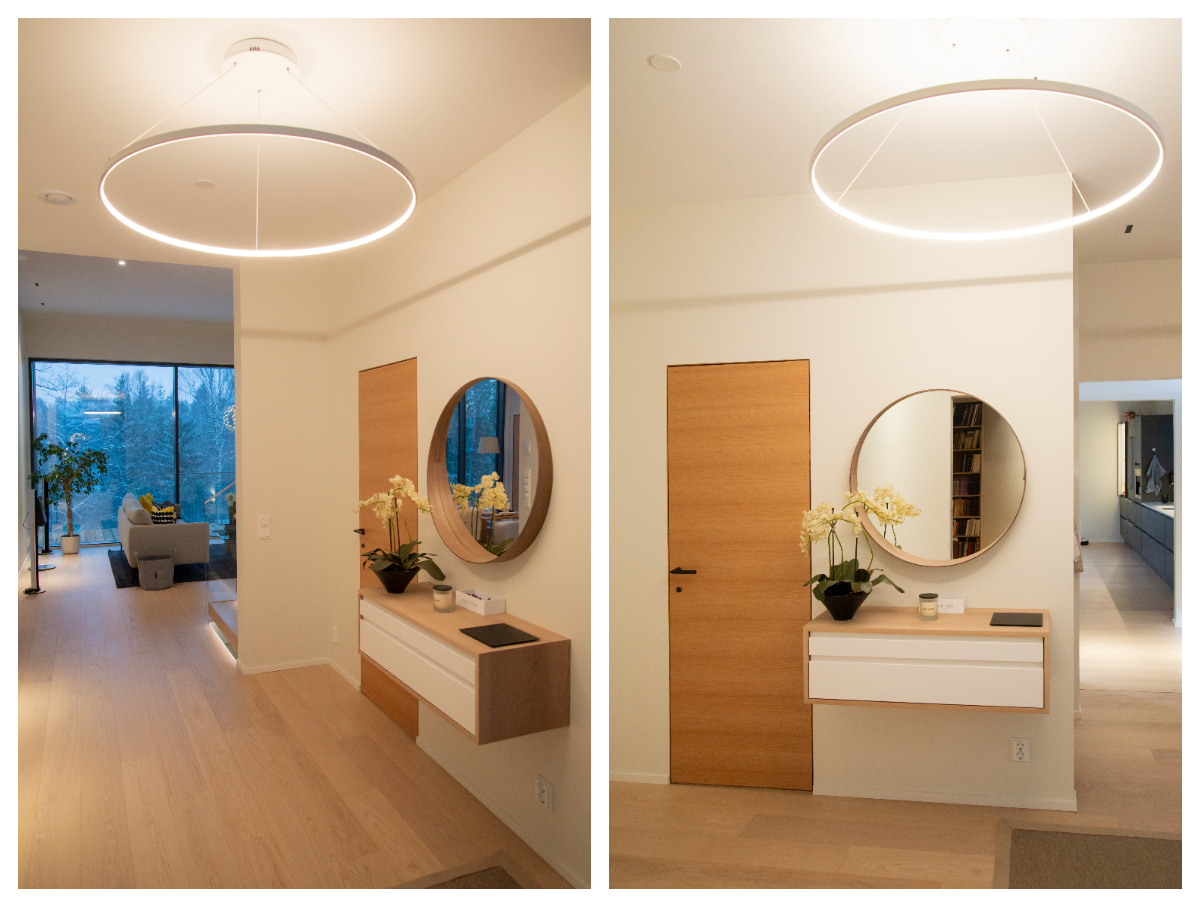 A modern hallway with Rinkeli pedant lamp, orchid and wall mirror. - LedStore Eteisessä sisustuksellinen kattovalo. Valkoinen kehä, jossa led-nauha sisäkehällä.