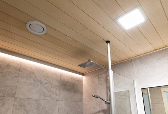 House Juutilainen ©LedStore (22) - LedStore LedStore.fi-verkkokaupan LED-valaistusratkaisuilla moderni kylpyhuone saa tyylikkään ilmeen. Kattopaneelissa käyttää vaaleaa puuta, johon upotettu LED-valaisin sekä pyöreä ilmastointiventtiili luovat minimalistisen vaikutelman. Sadevesisuihkun suutin on elegantisti kiinnitetty metalliseen tankoon vaaleanharmaan laatoitetun seinän yläpuolelle, ja sen rinnalla osittain näkyvä peili täydentää kokonaisuuden hienovaraisesti.