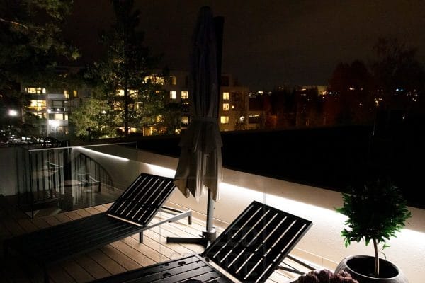 Terassivalaistuksen kaiteen alla led nauha valaisemassa epäsuorasti.