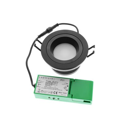 Black recessed LED downlight with green LED driver and black wire on white background - an energy efficient lighting solution.