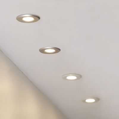 The ceiling view features four recessed LED lights that illuminate a clean white room and accentuate modern lighting solutions.