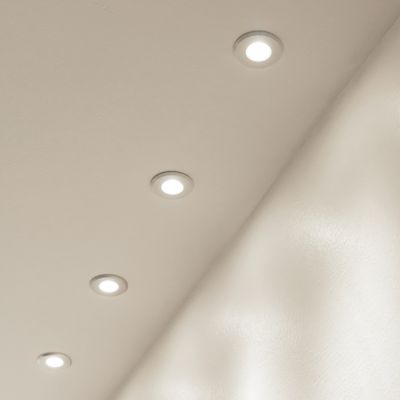 Recessed ceiling lights with diagonal placement to brighten a smooth, light surface.