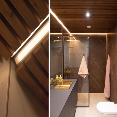 A modern bathroom, illuminated by ceiling LED lighting, highlighting the furniture and natural wood accents.