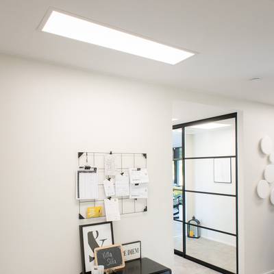 Office ceiling LED luminaires illuminate a modern workspace with a glass partition and a blackboard.