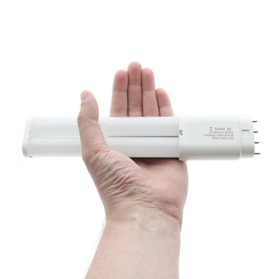 A person holding a stylish LED lamp with a metal spike and presenting modern and energy-efficient lighting solutions.