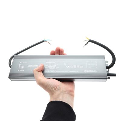Rectangular LED controller with wires in hand, on a white background - energy efficient lighting solutions in our LED shop.