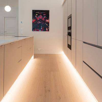 Light coloured kitchen base units with under plinth lighting.