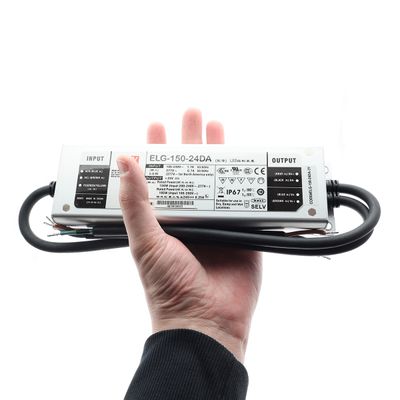 Hand-held LED lighting controller with input and output labels, with black cables extending from both ends for power connection.