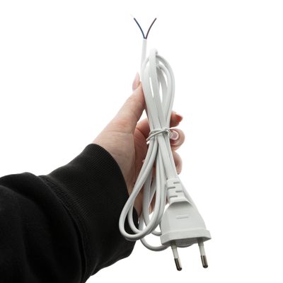 Close-up of a hand holding a twisted white electrical cable with a European two-prong plug and visible wires, ideal for LED lighting connections.