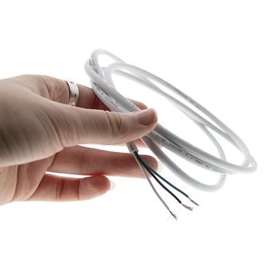 Close-up of a hand holding a white LED ring light with visible wires against a dark background for energy efficient lighting.