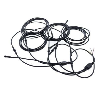 Long LED fibre optic cables with connectors and bare wires, on a white background, twisted for luminaires.