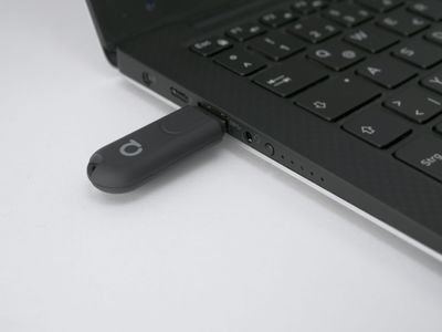 USB flash drive connected to a laptop on a white background, symbolising connectivity and technology in modern LED lighting solutions.