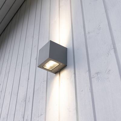 A modern square grey wall light, shining with a white wood panelled exterior, enhances outdoor living and energy efficiency.