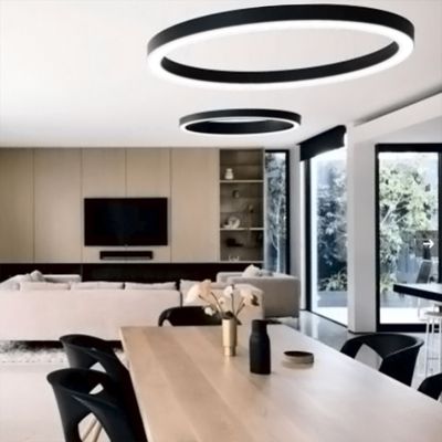 Modern LED ceiling lights illuminate a spacious living/dining area with wooden table, beige sofa, TV on the wall, large windows and minimalist decor.