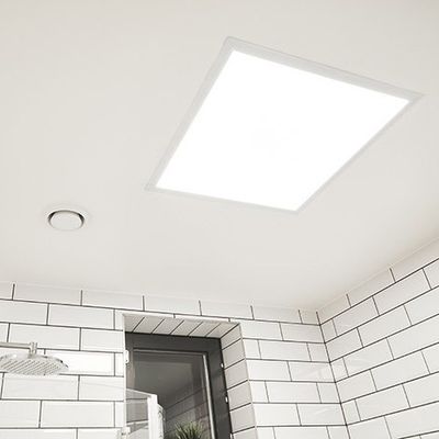 Modern bathroom with white subway tiles and rectangular LED ceiling light for bright and efficient lighting.
