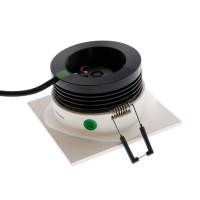 Black and white square LED downlight with spring clip and black wire on a white surface - the perfect modern lighting solution.
