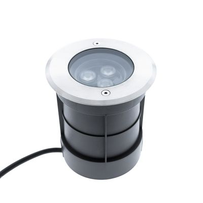 Grounded round LED light with silver frame, black housing and power cord, ideal for garden paths and outdoor lighting.