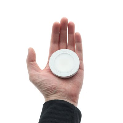 Energy-efficient, compact LED lamp in hand for environmentally friendly lighting solutions against a white background. Perfect for modern home lighting.