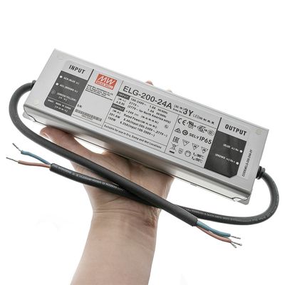 Close-up of the hand-held Mean Well ELG-200-24A LED controller with visible input and output wires, ideal for energy-efficient LED lighting solutions.