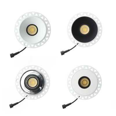 "A set of four round LED lights with white edges, contrasting black and white interiors and short black connecting cables.