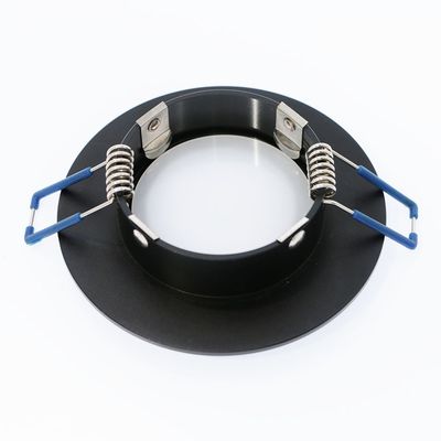 Black flush-mounted LED downlight frame with metal spring clips and blue stem ends, top side.