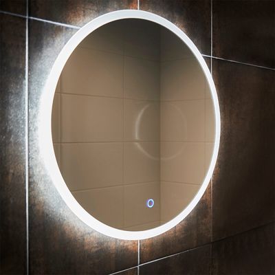 Round LED mirror on a tiled wall, reflecting the empty room. A visible blue button on the surface of the mirror adds to the appeal of the modern lighting movement.