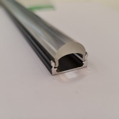 Close-up of an aluminium LED profile with a rounded diffuser on a white background, elegant design and modern lighting solution.
