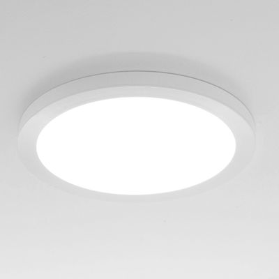 A round white brightly glowing LED ceiling light mounted on a white ceiling to enhance modern home lighting. Ideal for energy efficient lighting.