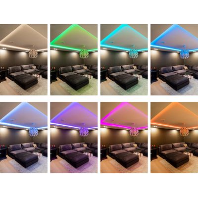 Living room with cross-section sofa with eight LED ceiling light colours: warm white, green, cyan, blue, purple, pink, magenta. A cosy atmosphere.