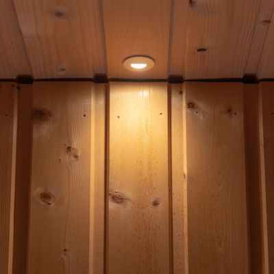 A warm, natural wooden ceiling with recessed LED lighting and vertical panels for a cosy atmosphere.