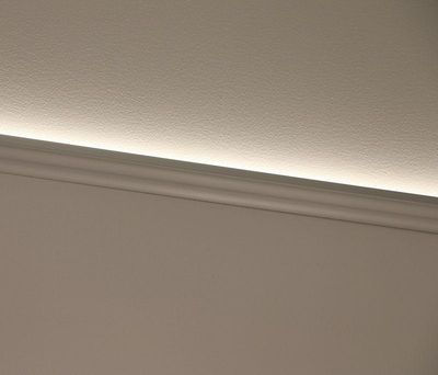 A modern white skirting board with a subtle LED light effect above that illuminates the wall, emphasising a clean and contemporary design.