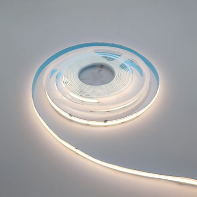 Twisted LED strip light, partially unrolled, glows softly on a plain white surface. Perfect for energy efficient home and business lighting solutions.
