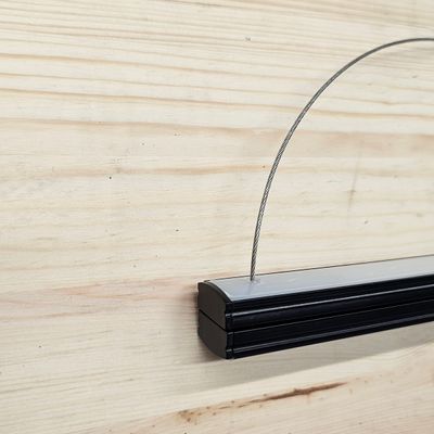 Close-up of a black frame with a wireframe in a light wood finish, ideal for modern LED lighting display in home interior design and decoration.