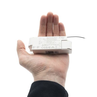 A person holds an LED light control displaying size and function, showcasing modern lighting technology in a store.