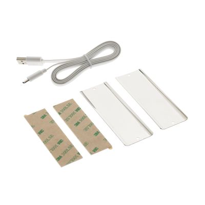 LED lighting installation kit: USB cable, adhesive strips and rectangular white plastic parts with white background.
