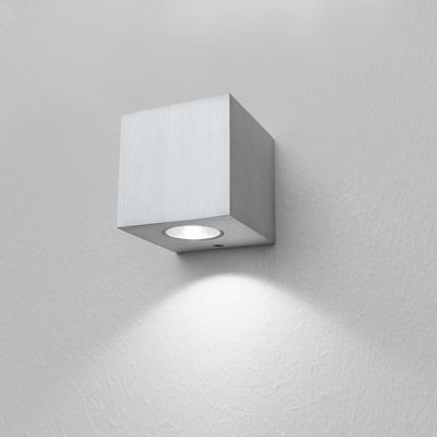A minimalist square LED wall light that creates a warm glow on an elegant white wall, perfect for modern interiors.