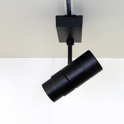 Close-up of a black cylindrical strip light on a white ceiling for modern LED lighting solutions.