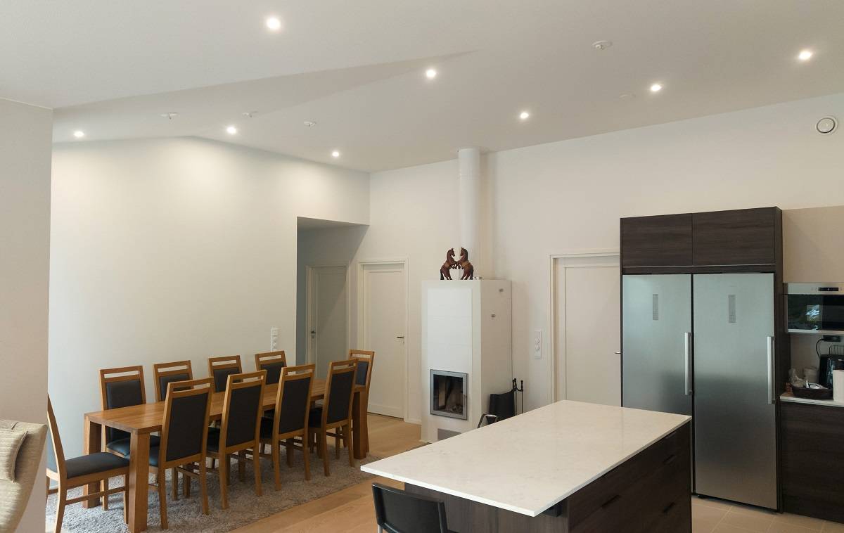 Spotlights evenly spaced across the ceiling of the kitchen and dining area—