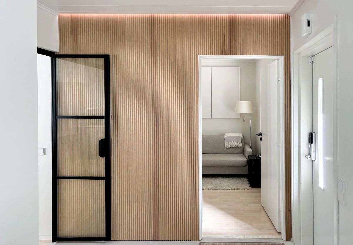 In the hallway, a led strip light in the groove between the wall panel and the ceiling creates a soft atmosphere in the space, in a neutral tone on the velo