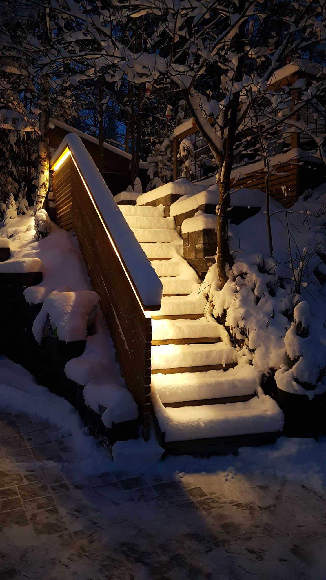 Exterior staircase lighting implemented with LED strip on the balustrade. The light is atmospheric indirect light, the LED strip used is a warm 3000K 7,2W/m strip. Ledstore.fi