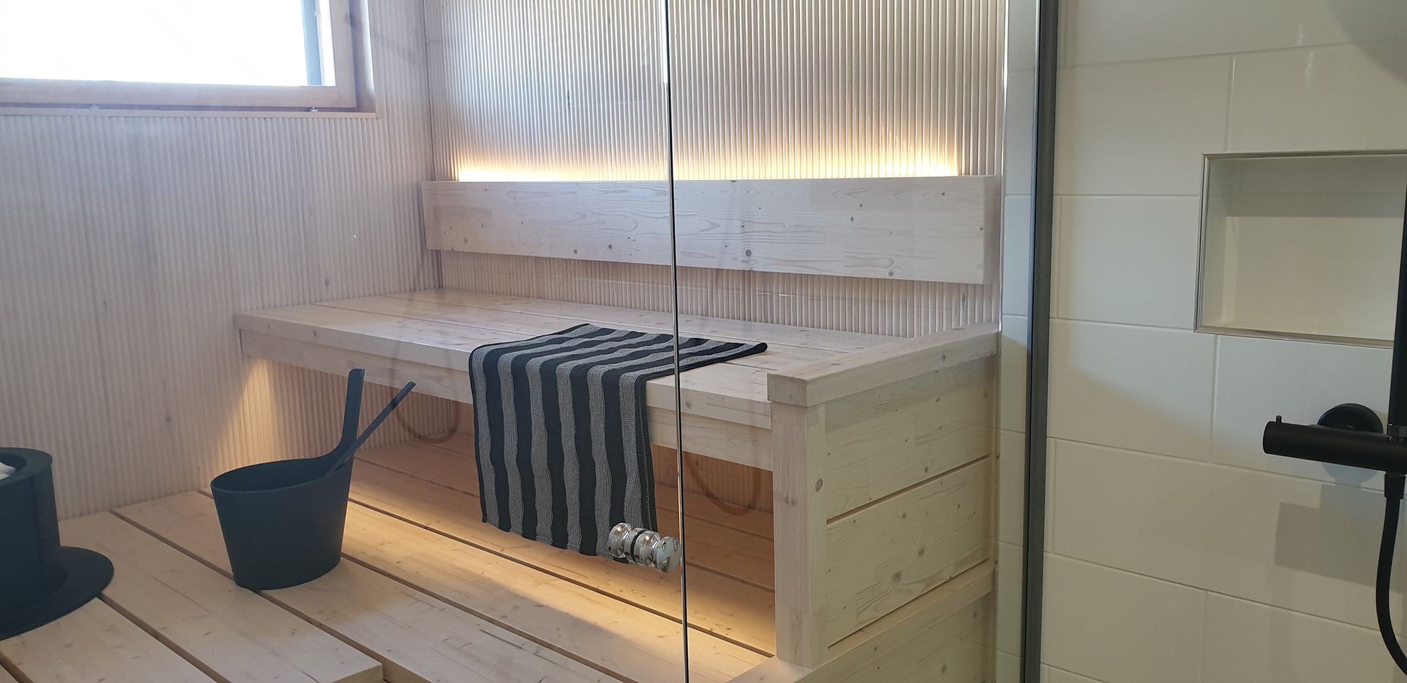 LED strip on the back of the sauna backrest illuminates atmospheric light upwards and downwards under the ceiling. Ledstore.fi