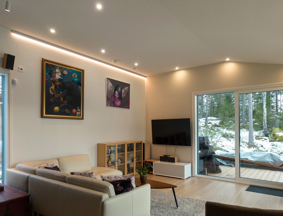 Living room with several spotlights and one wall with LED strip lighting.