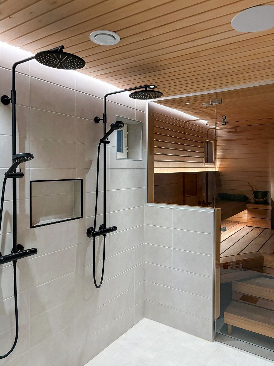 Behind the showers, an LED strip light in a groove in the ceiling line indirectly illuminates along the wall to the floor. The light is both efficient and eye-friendly. © LedStore.fi