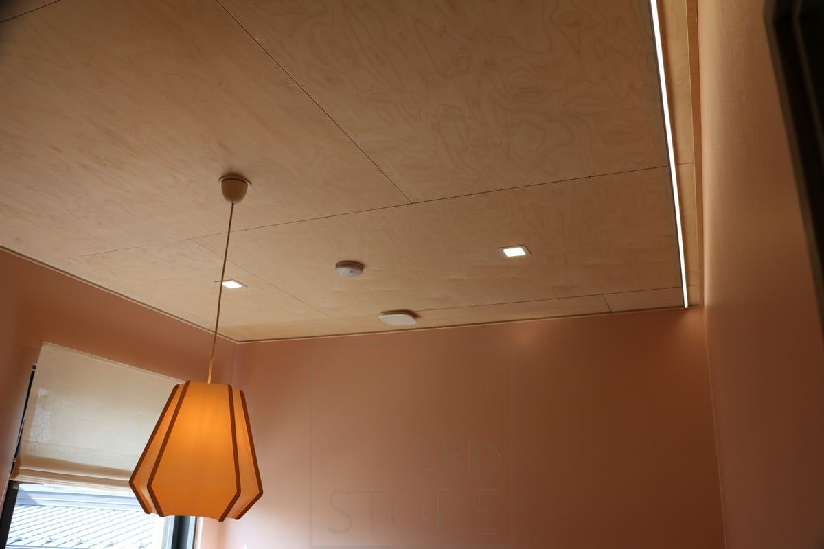 Housing Fair 2019: Small panel lights on a plywood roof. Led strip illuminating the wall for indirect light. Ledstore.fi
