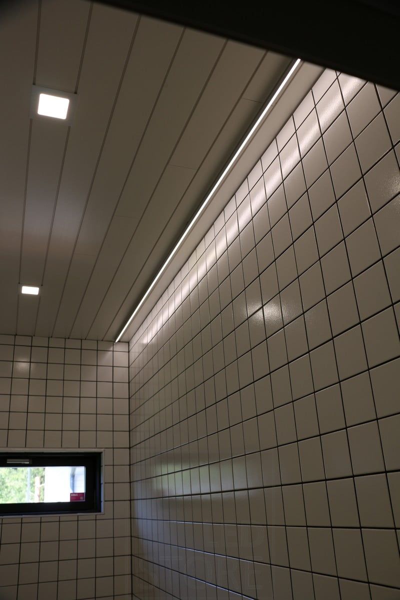 Housing Fair 2019: Led strip on the ceiling next to the wall, light reflected from the glossy tile. Ledstore.fi