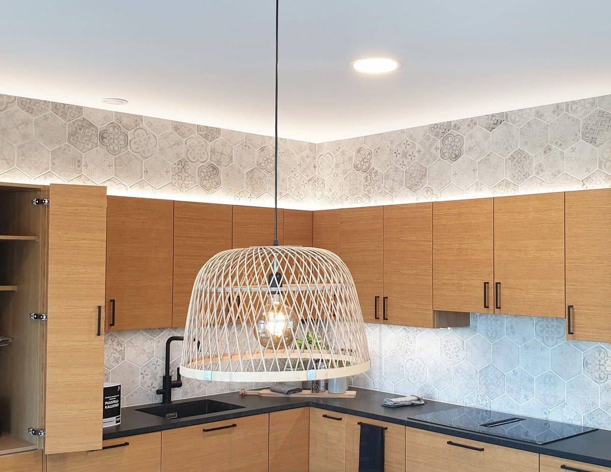 Housing Fair 2020: indirect lights in the kitchen cupboard on top of the oak kitchen. Plafonds in the ceiling and a pendant light above the dining table. Ledstore.fi